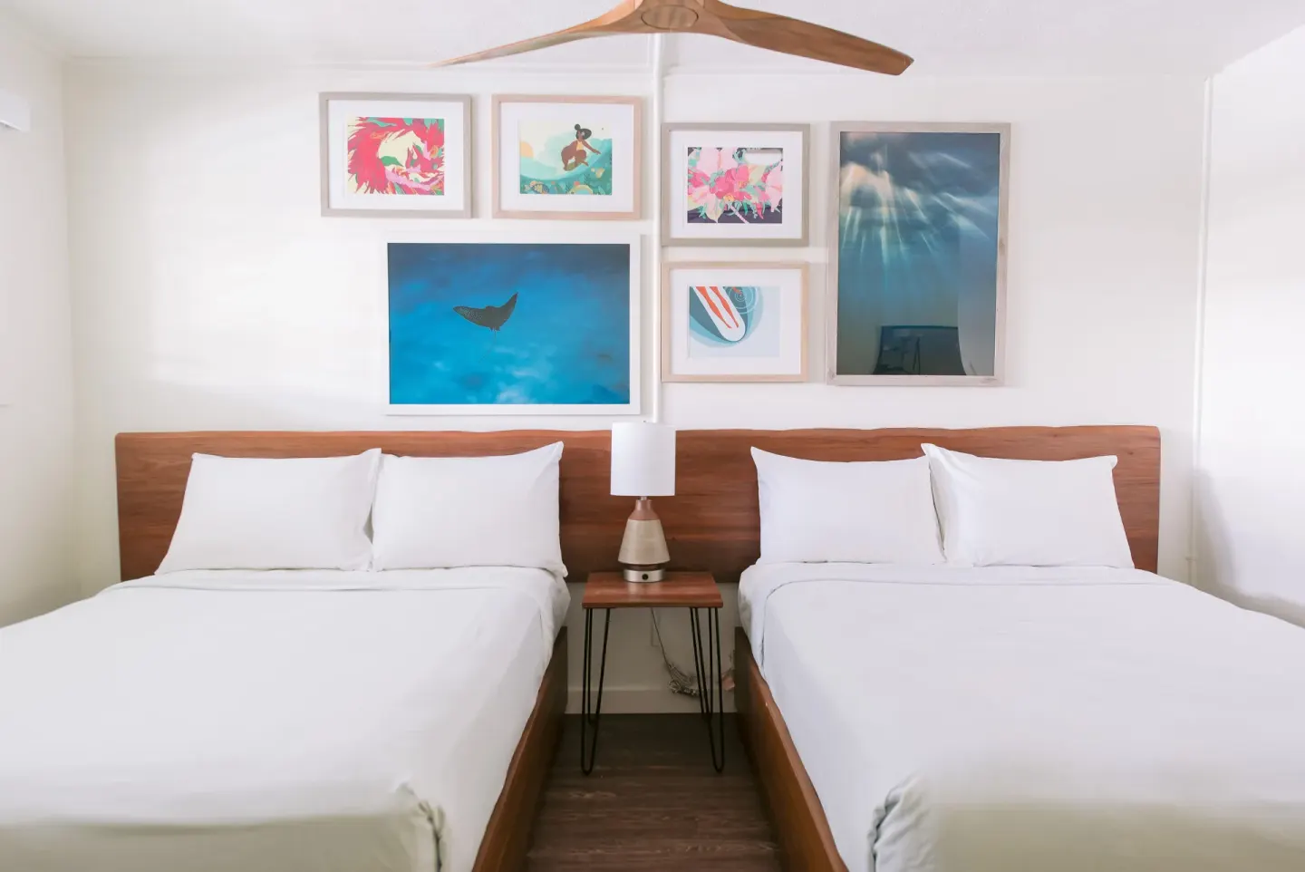 Two-bed poolside guest room with framed ocean-inspired art at SCP Hilo Hotel.
