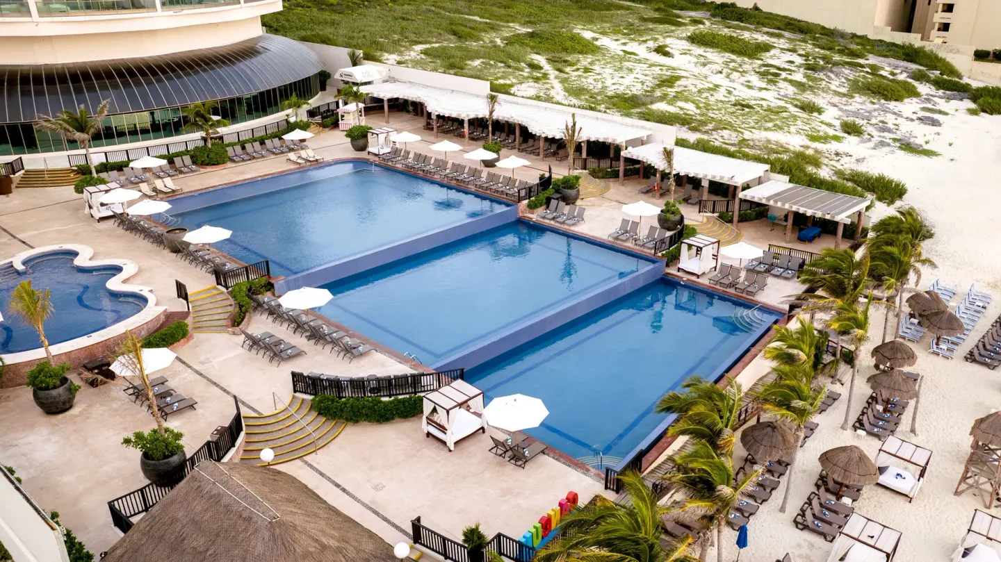 Aerial view of pools and beachfront deck at Seadust Cancún Family Resort.