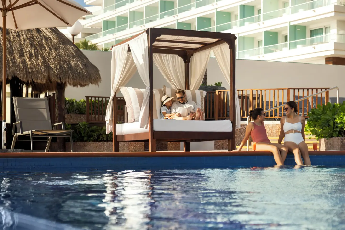 Poolside cabana and guests by the water at Seadust Cancún Family Resort.