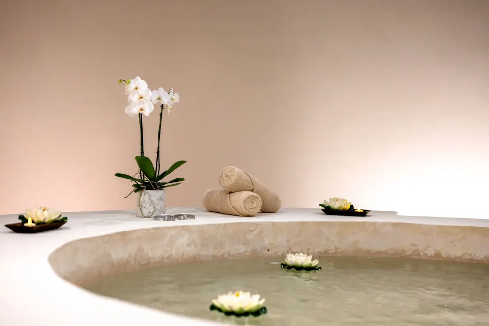 Spa soaking tub with floating flowers and towels at Seadust Cancún Family Resort.
