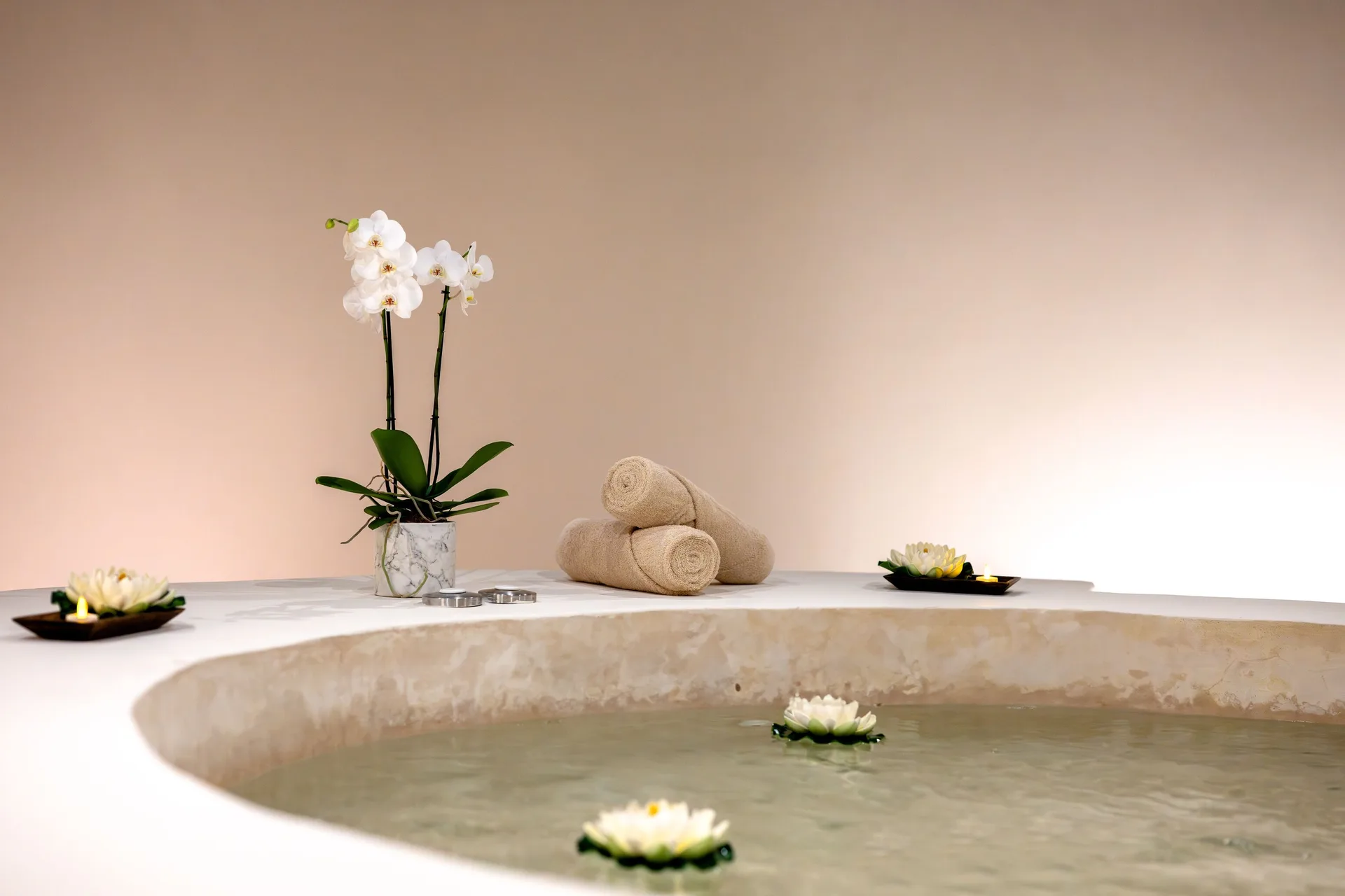 Spa soaking tub with floating flowers and towels at Seadust Cancún Family Resort.