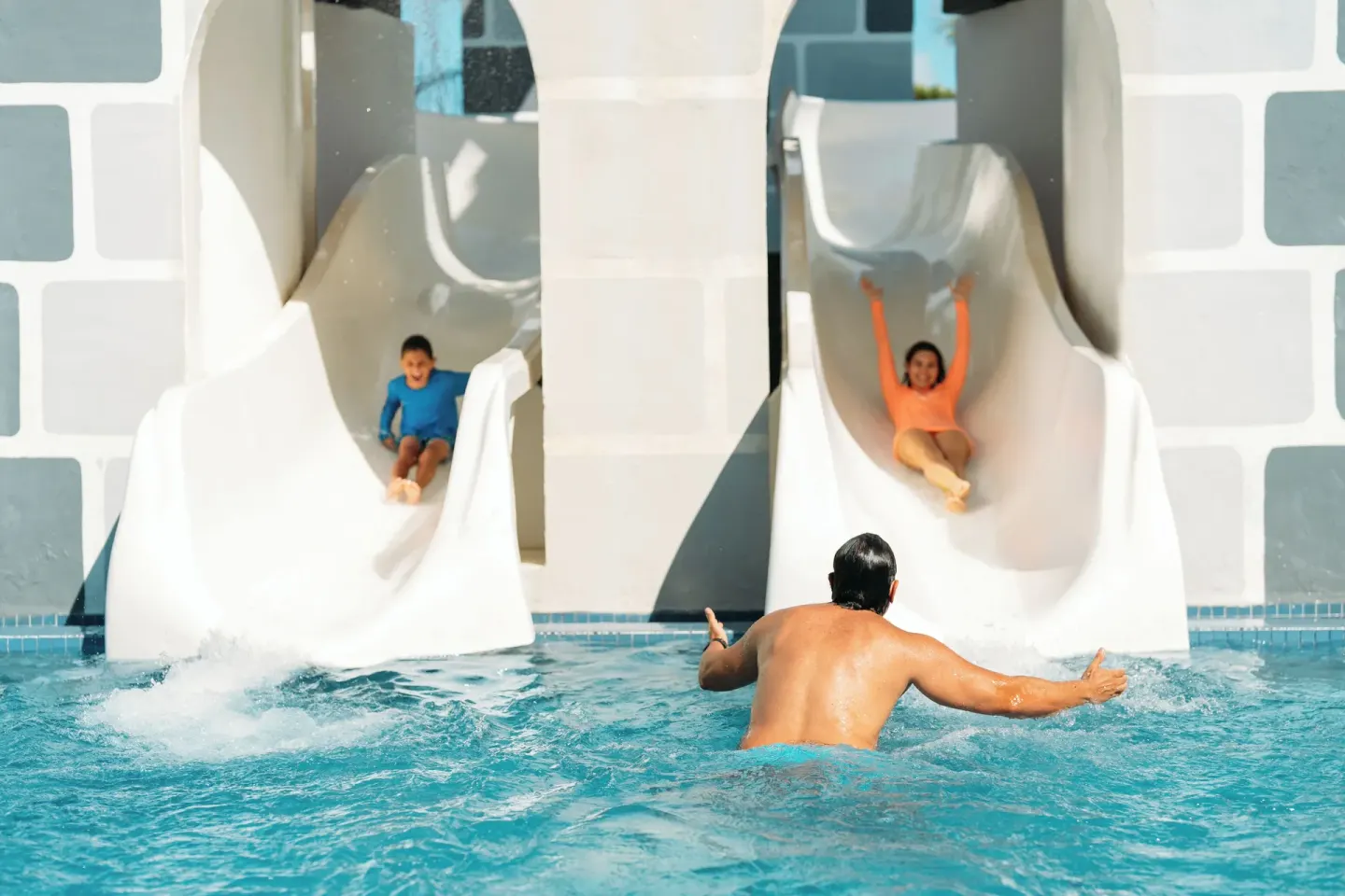 Children sliding into a pool at Seadust Cancún Family Resort.