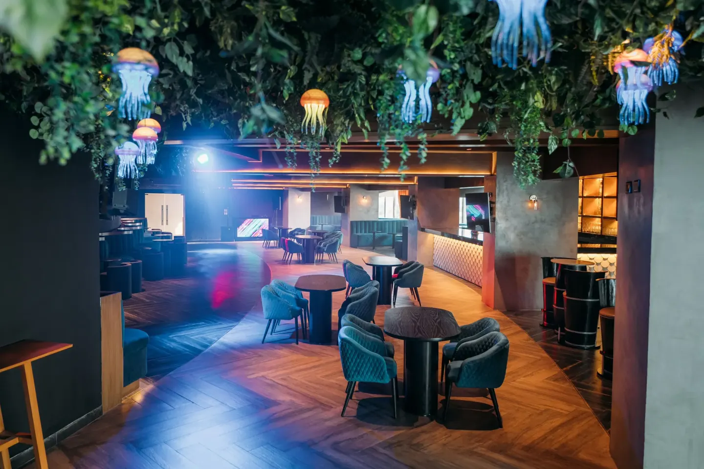Club-style lounge with tables and jellyfish lights at Seadust Cancún Family Resort.