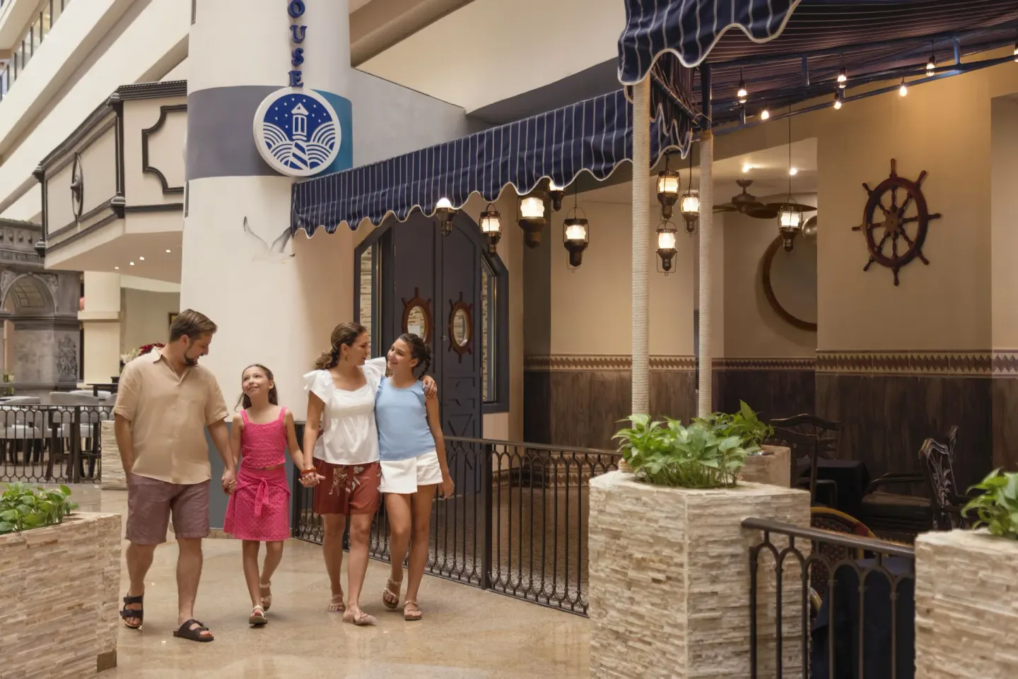 Family walking past Lighthouse restaurant entrance at Seadust Cancún Family Resort.