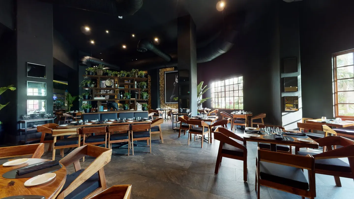Modern restaurant dining room with black walls and wood tables at Seadust Cancún Family Resort.