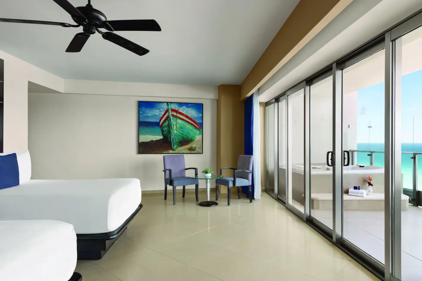 Oceanfront Suite king bed and balcony tub area at Seadust Cancún Family Resort.