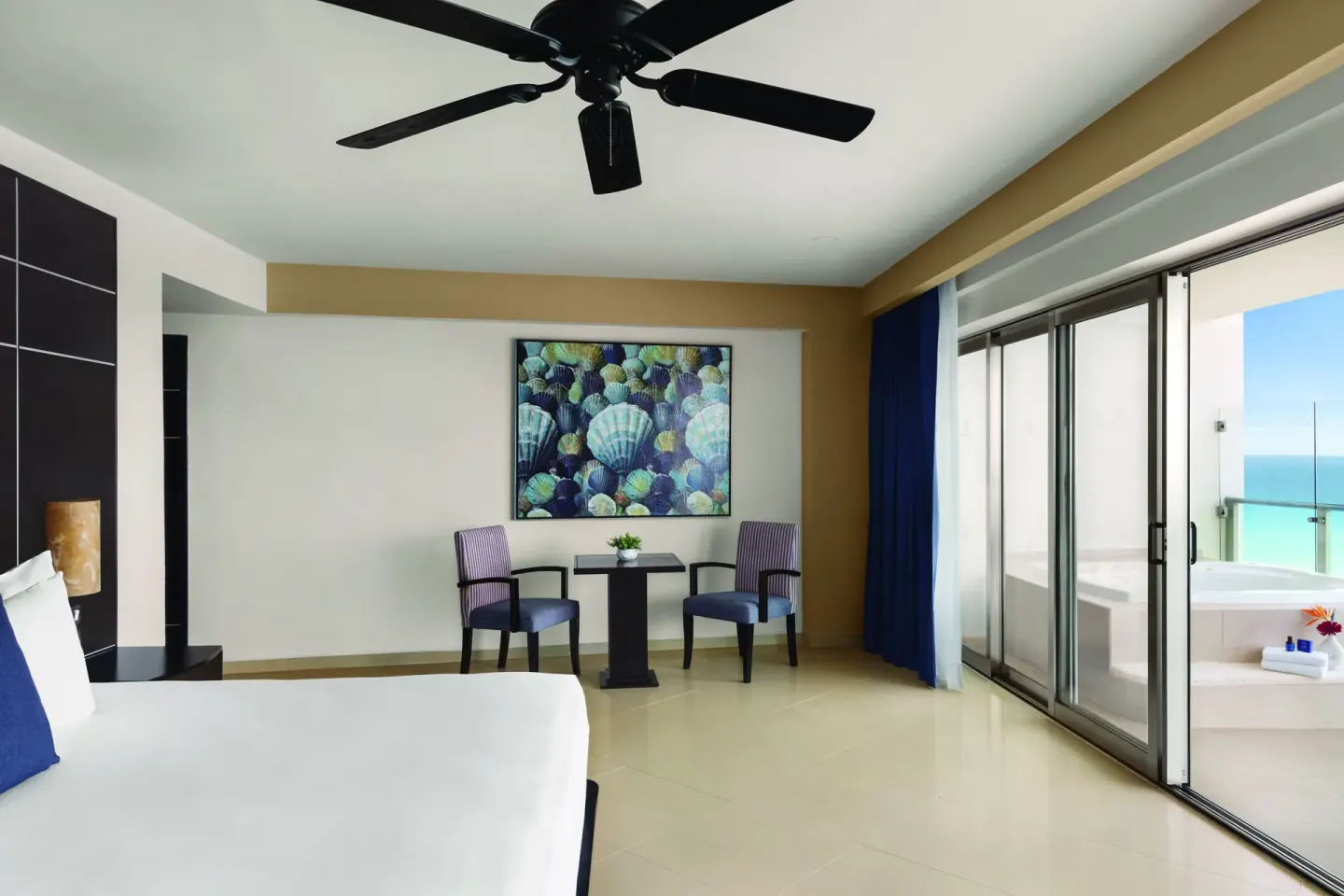 Oceanfront Suite bedroom with king bed and balcony tub at Seadust Cancún Family Resort.