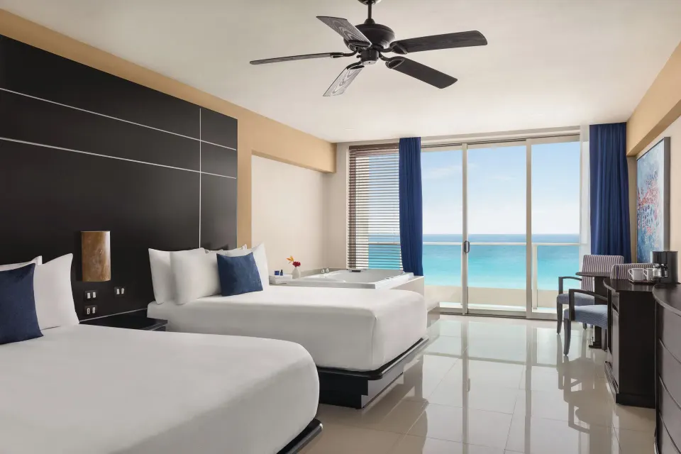 Premier Suite with two beds, soaking tub and ocean-facing balcony at Seadust Cancún Family Resort.