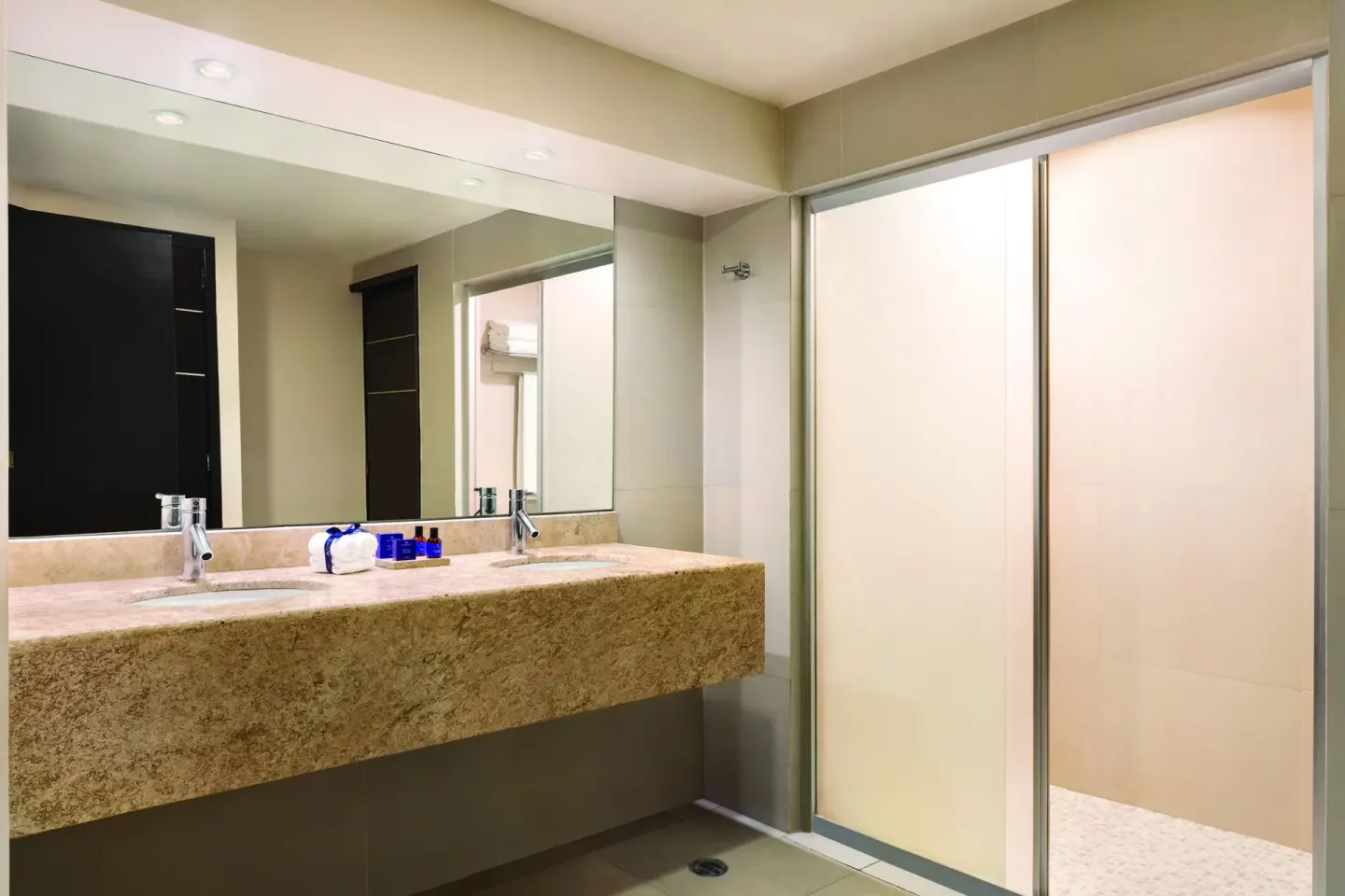 Standard Suite bathroom with double vanity and shower at Seadust Cancún Family Resort.
