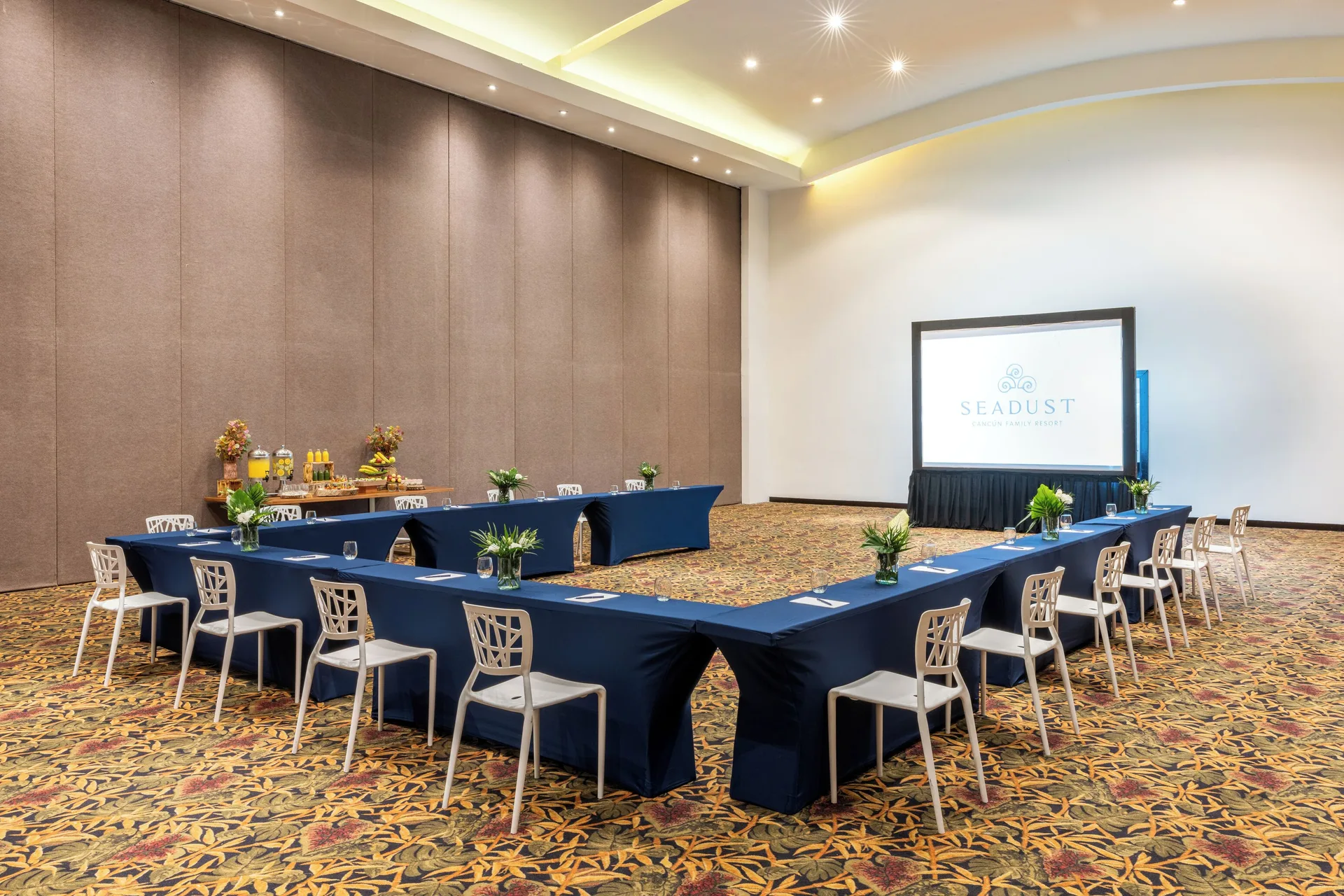 U-shaped meeting room setup with projection screen at Seadust Cancún Family Resort.