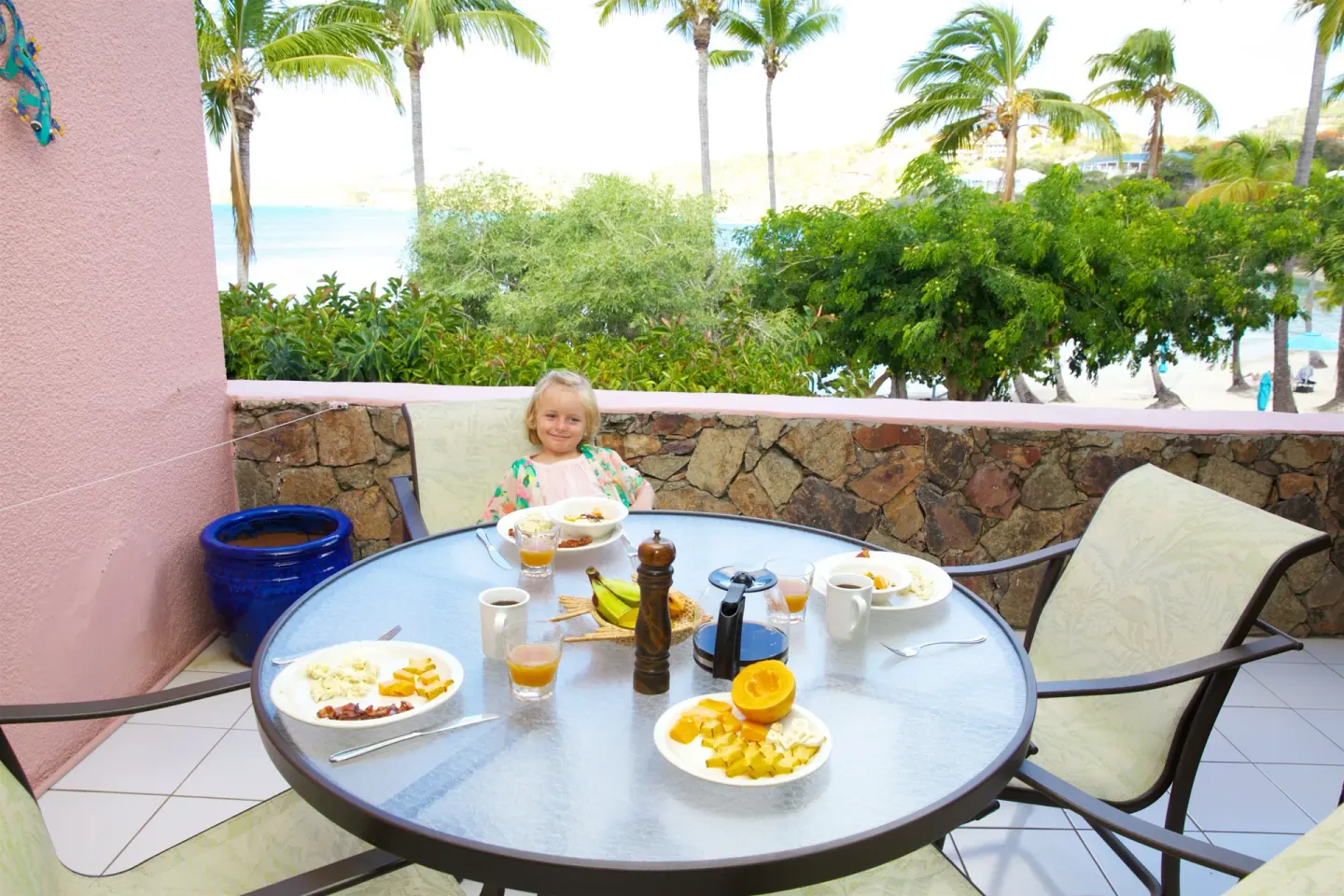 Balcony dining table at Secret Harbour Beach Resort set with breakfast and beach views.