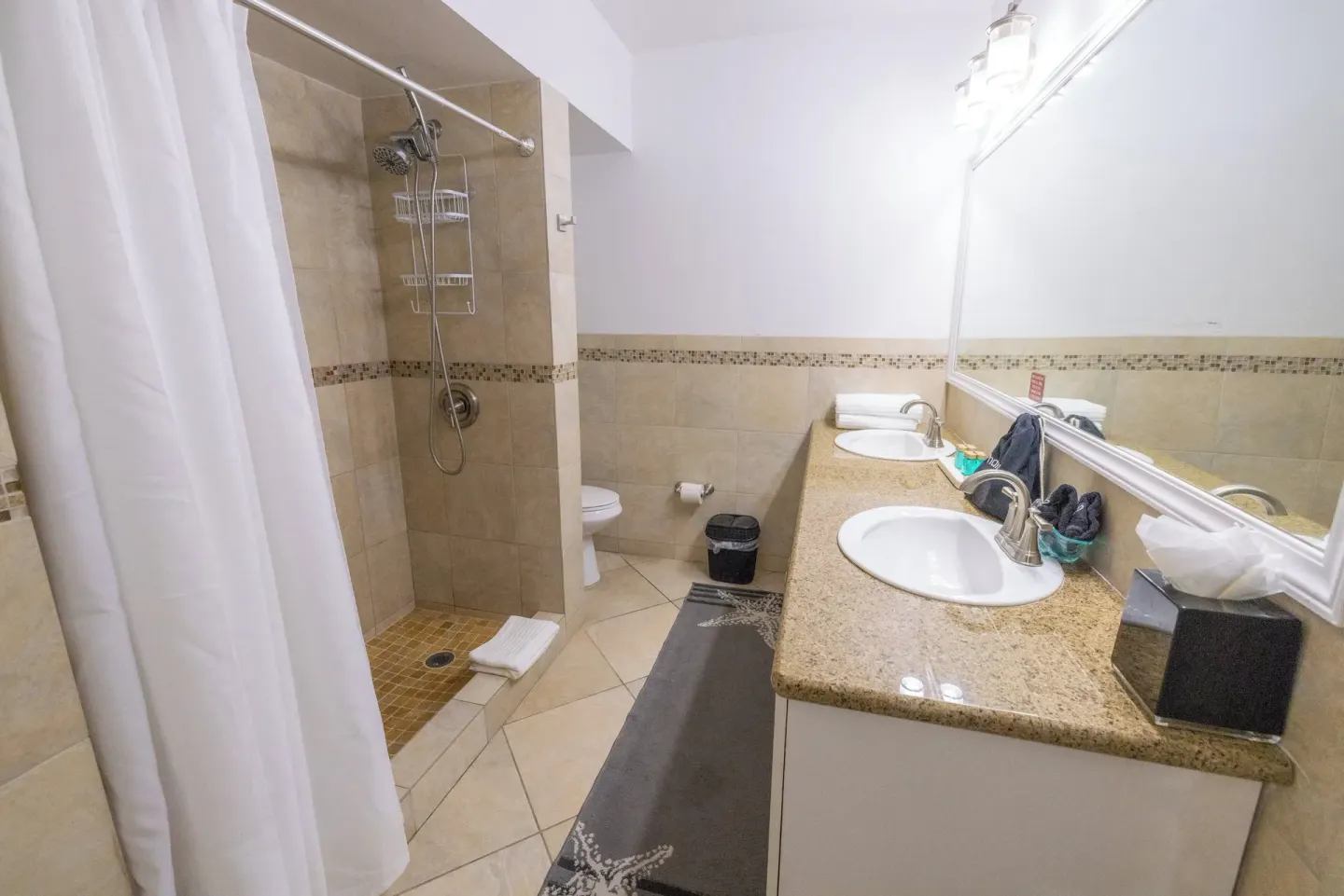 Bathroom with double sinks and walk-in shower at Secret Harbour Beach Resort.