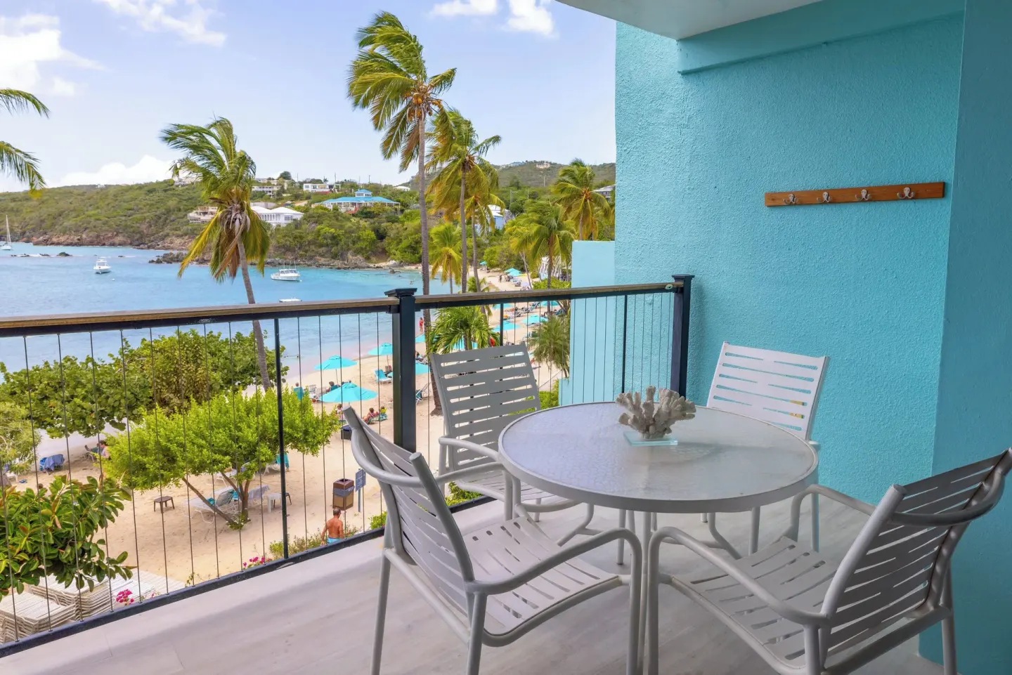 Beach-view balcony with white table and chairs at Secret Harbour Beach Resort.