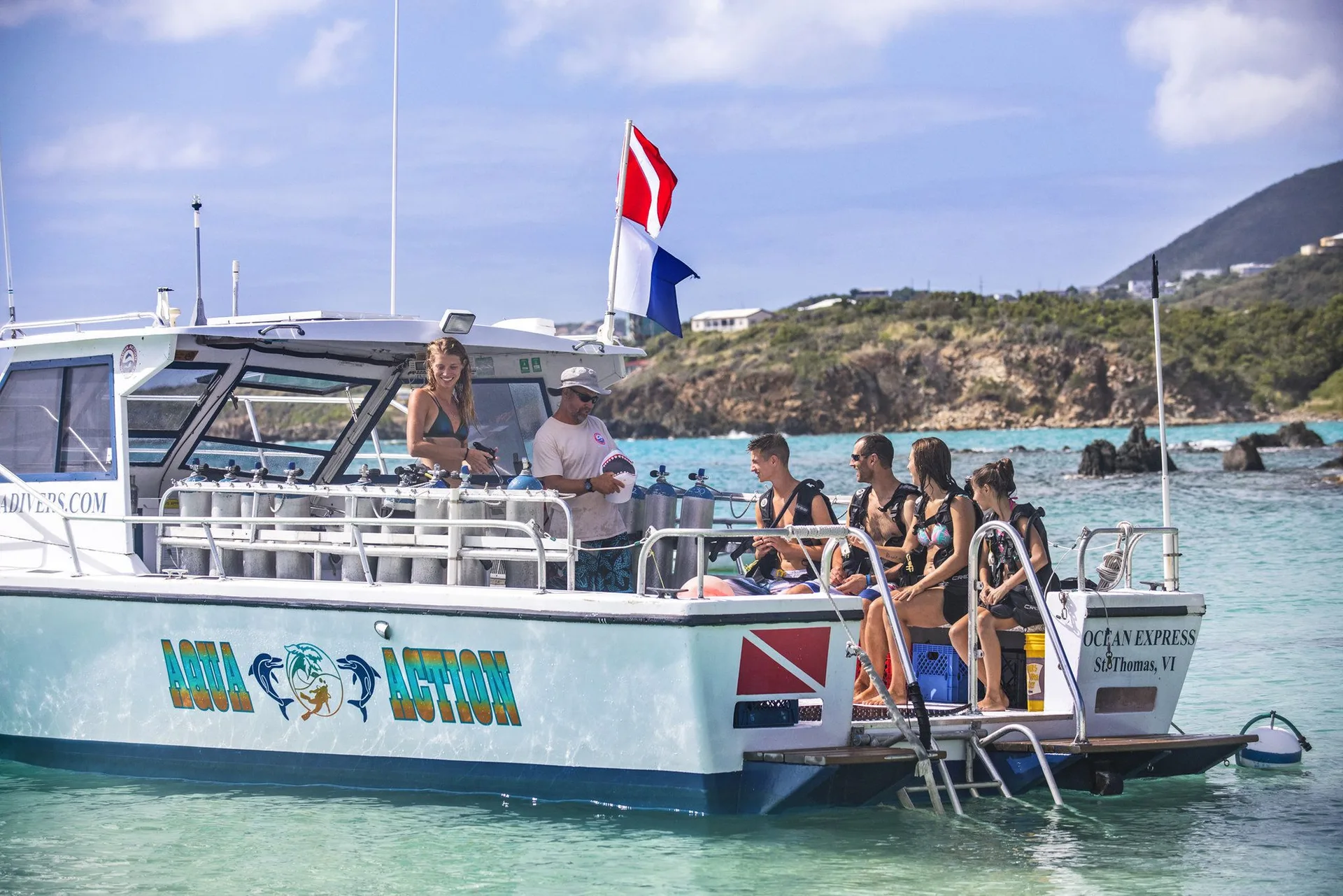 Divers board a boat in turquoise water at Secret Harbour Beach Resort.
