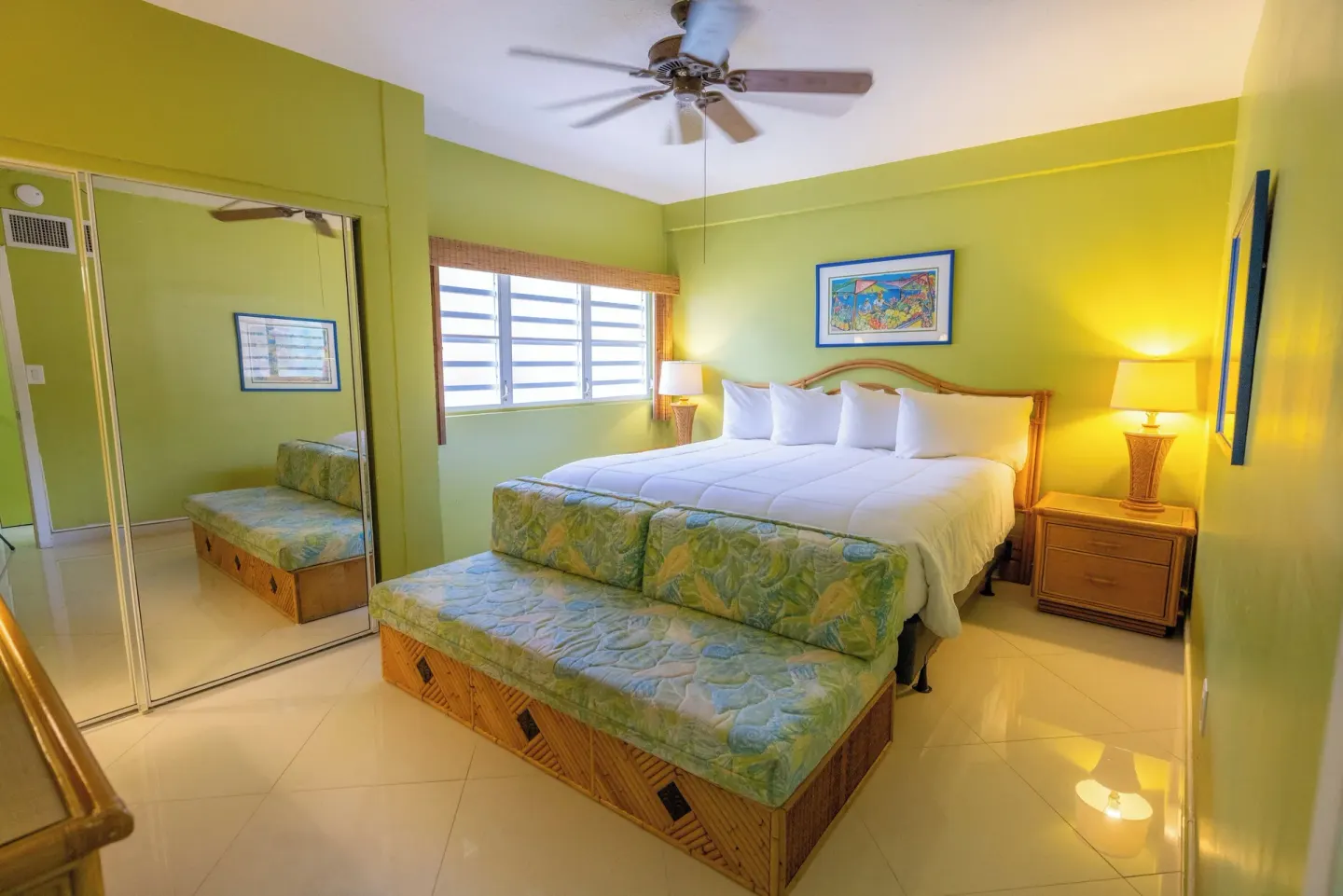 Green bedroom with king bed and mirrored closet at Secret Harbour Beach Resort.