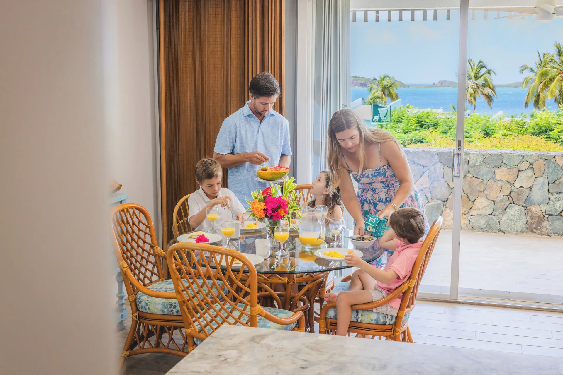 Family dining indoors by an ocean-view patio at Secret Harbour Beach Resort.