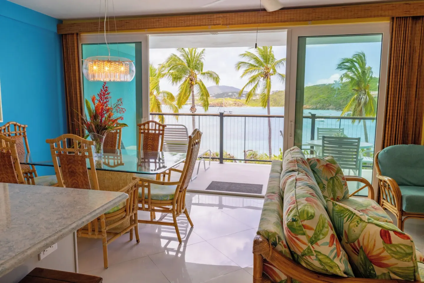 Suite dining area at Secret Harbour Beach Resort beside sliding doors to a waterfront balcony.