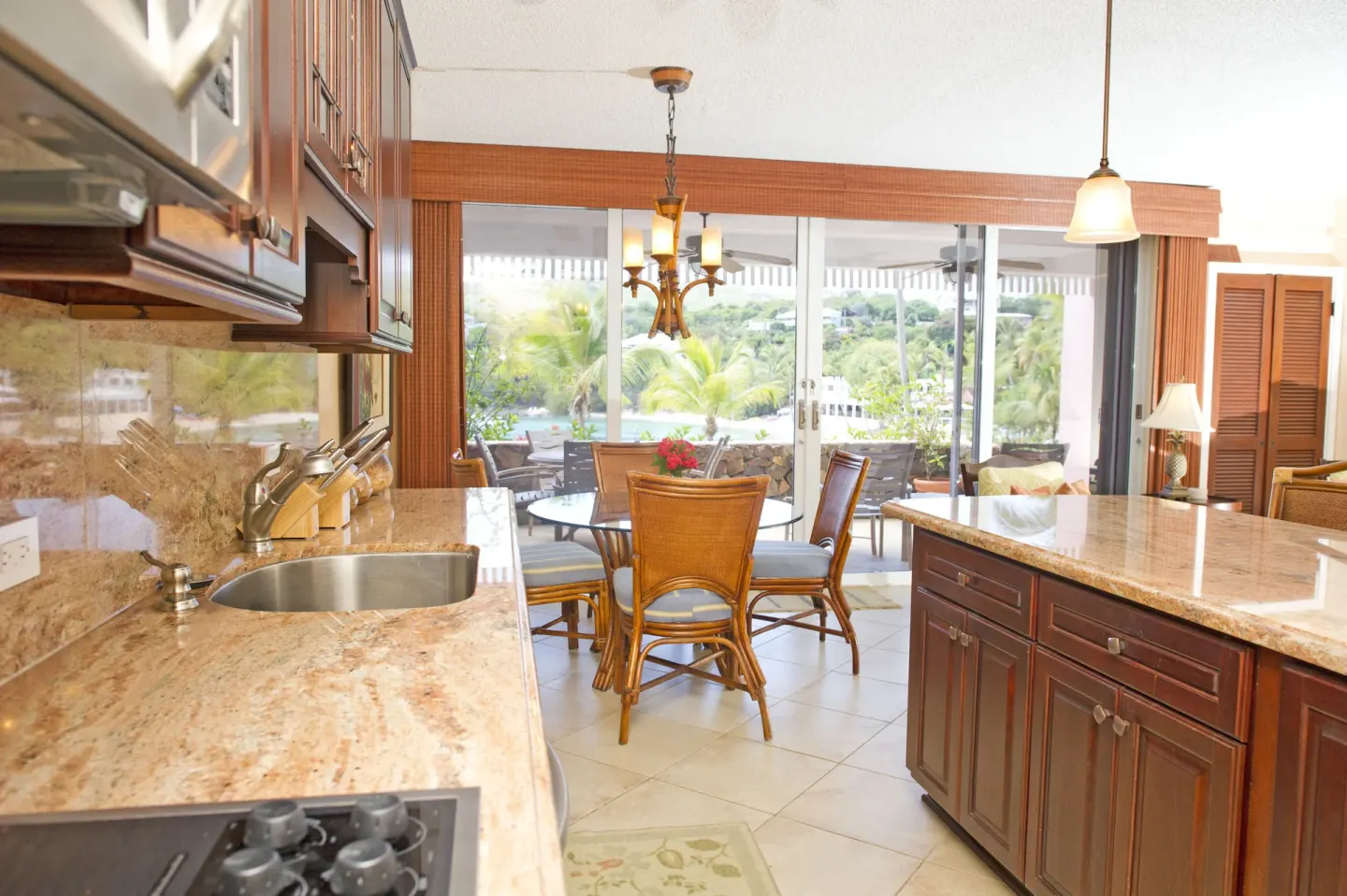 Open kitchen and dining area in a suite at Secret Harbour Beach Resort with patio beyond.