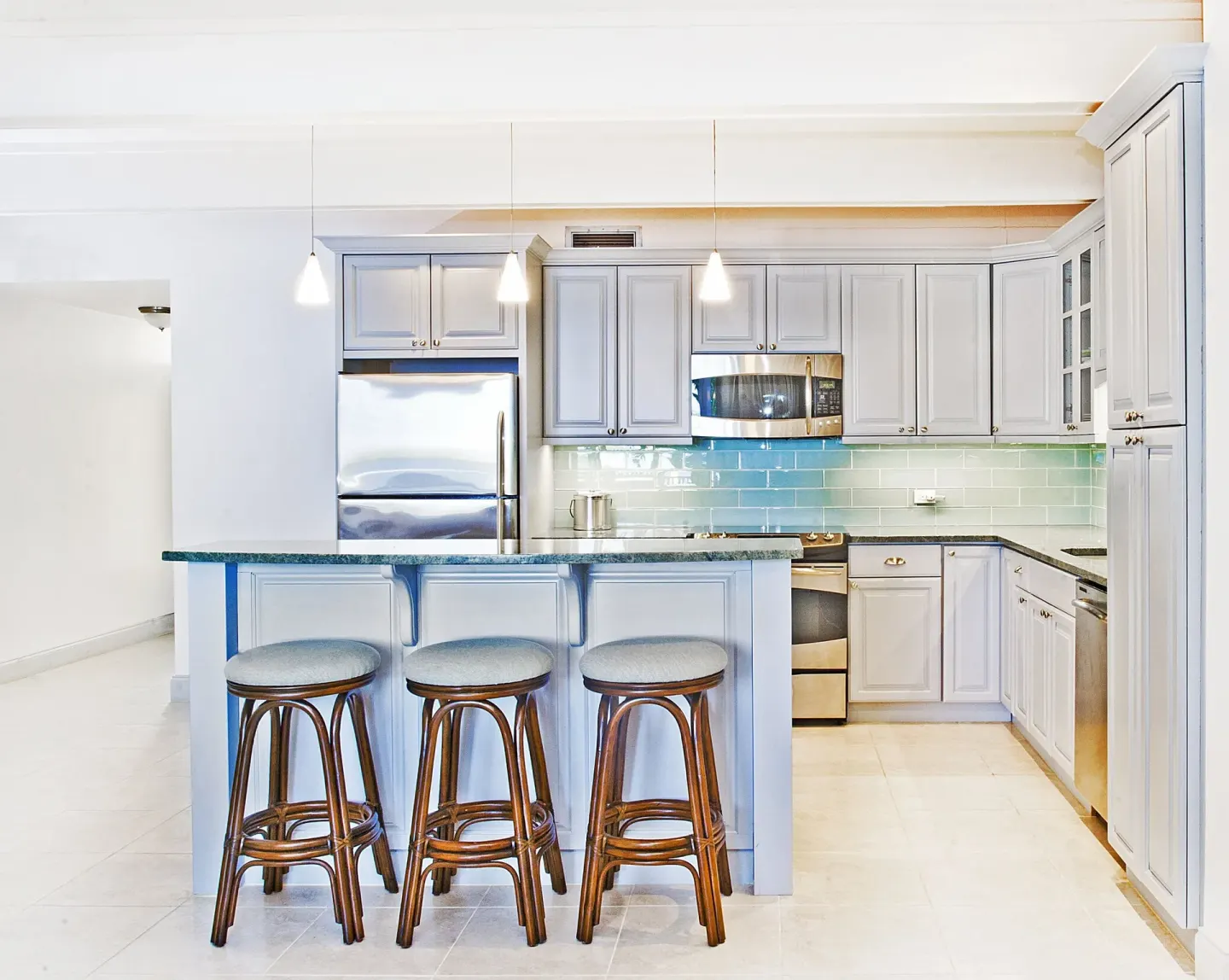 Bright suite kitchen at Secret Harbour Beach Resort with bar seating and stainless appliances.