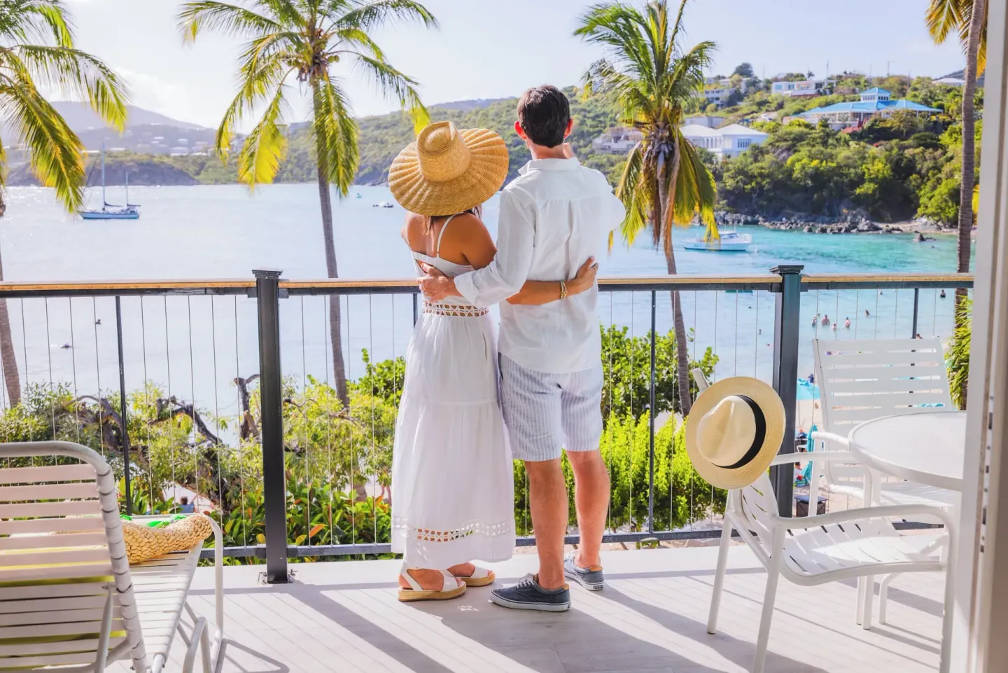 Couple on a sunny balcony above the bay at Secret Harbour Beach Resort.