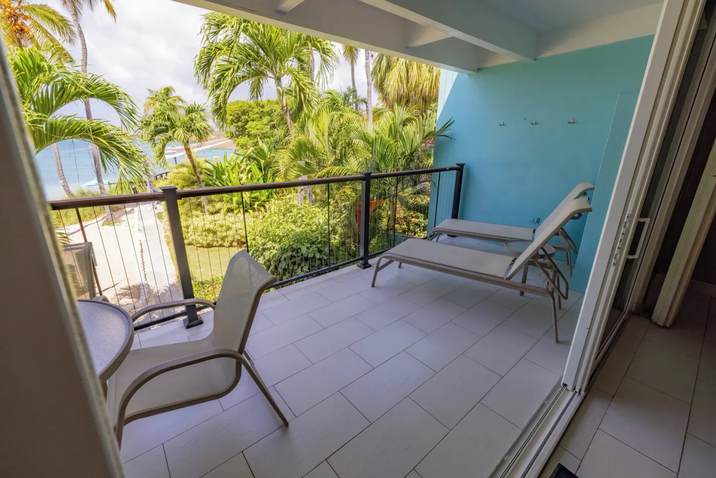 Balcony with lounge chairs and tropical garden view at Secret Harbour Beach Resort.