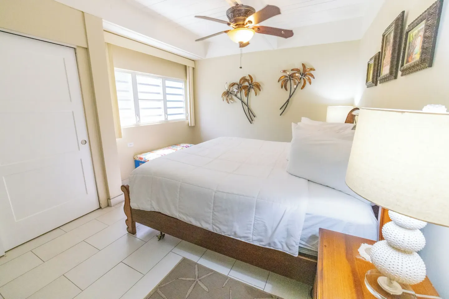 Beachfront one-bedroom condo bedroom with white bed at Secret Harbour Beach Resort.