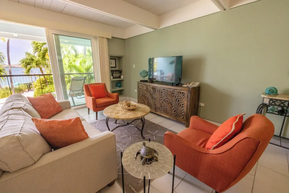 Beachfront one-bedroom condo living room with balcony view at Secret Harbour Beach Resort.