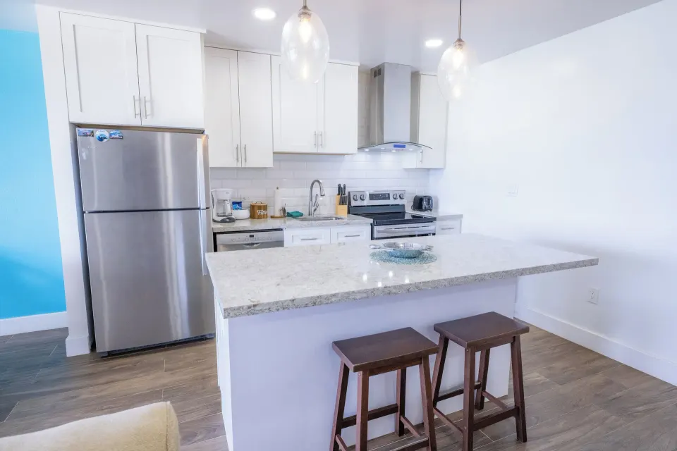 White kitchen with breakfast bar in a one bedroom condo at Secret Harbour Beach Resort.