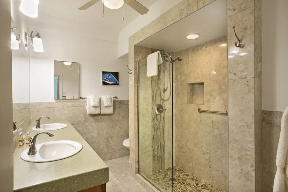 One-bedroom hillside condo bathroom with glass shower at Secret Harbour Beach Resort.