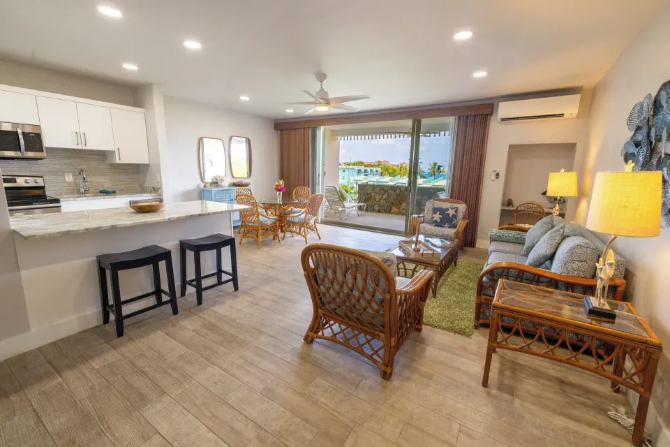 Hillside two-bedroom condo living room with kitchen and balcony at Secret Harbour Beach Resort.