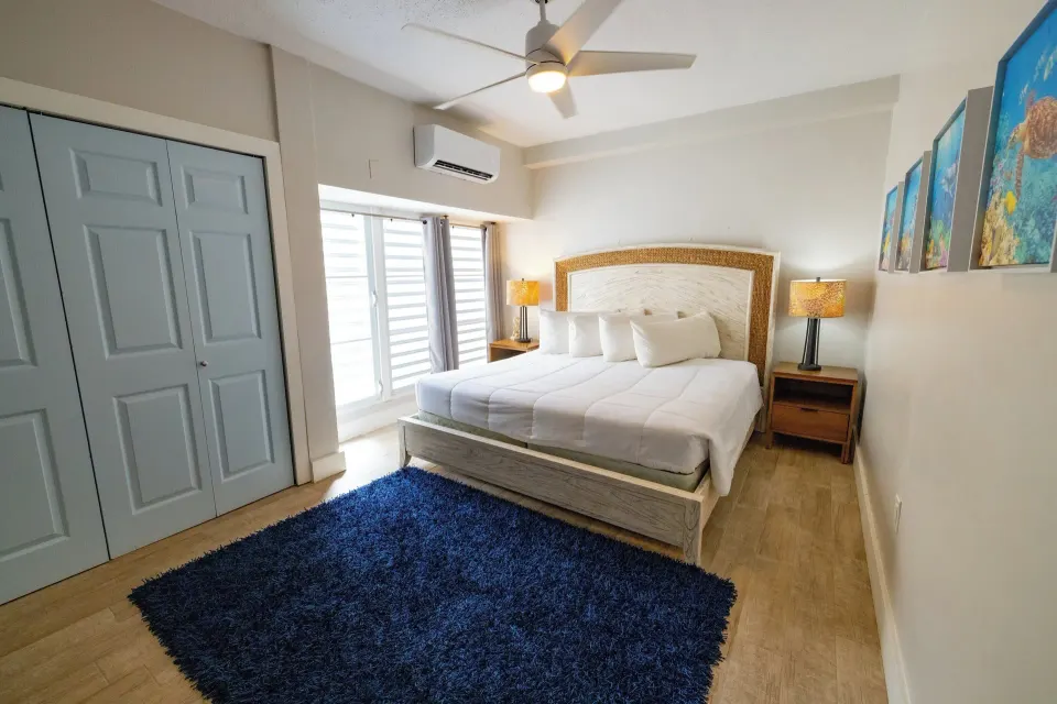 Hillside two-bedroom condo bedroom with white bed at Secret Harbour Beach Resort.