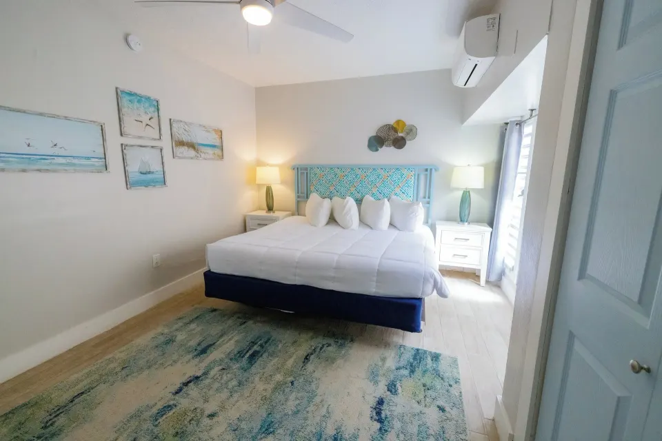 King bedroom with turquoise headboard in a hillside condo at Secret Harbour Beach Resort.