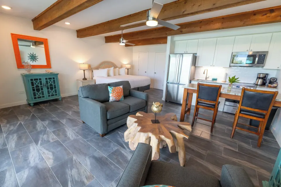 Beachfront Studio Suite king bed, lounge seating, and kitchen at Secret Harbour Beach Resort.
