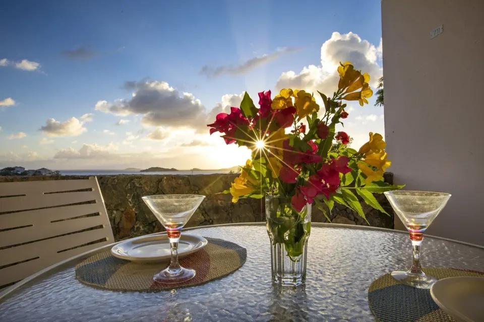 Studio Suite balcony table with flowers and sunset view at Secret Harbour Beach Resort.