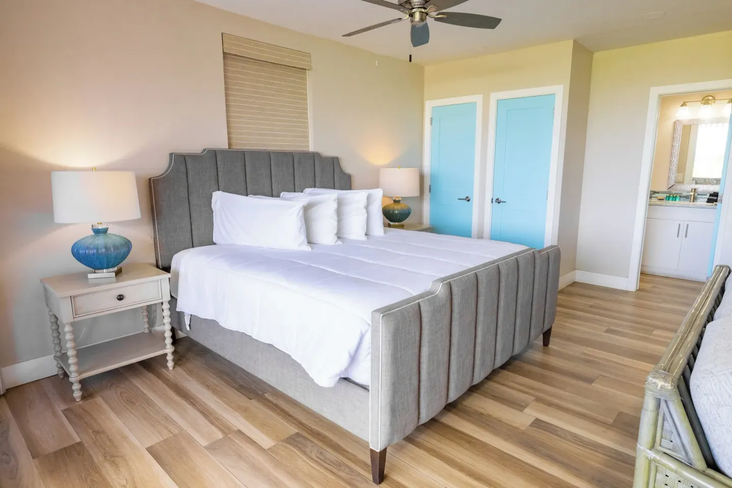 Studio Suite king bed beside blue doors and vanity area at Secret Harbour Beach Resort.
