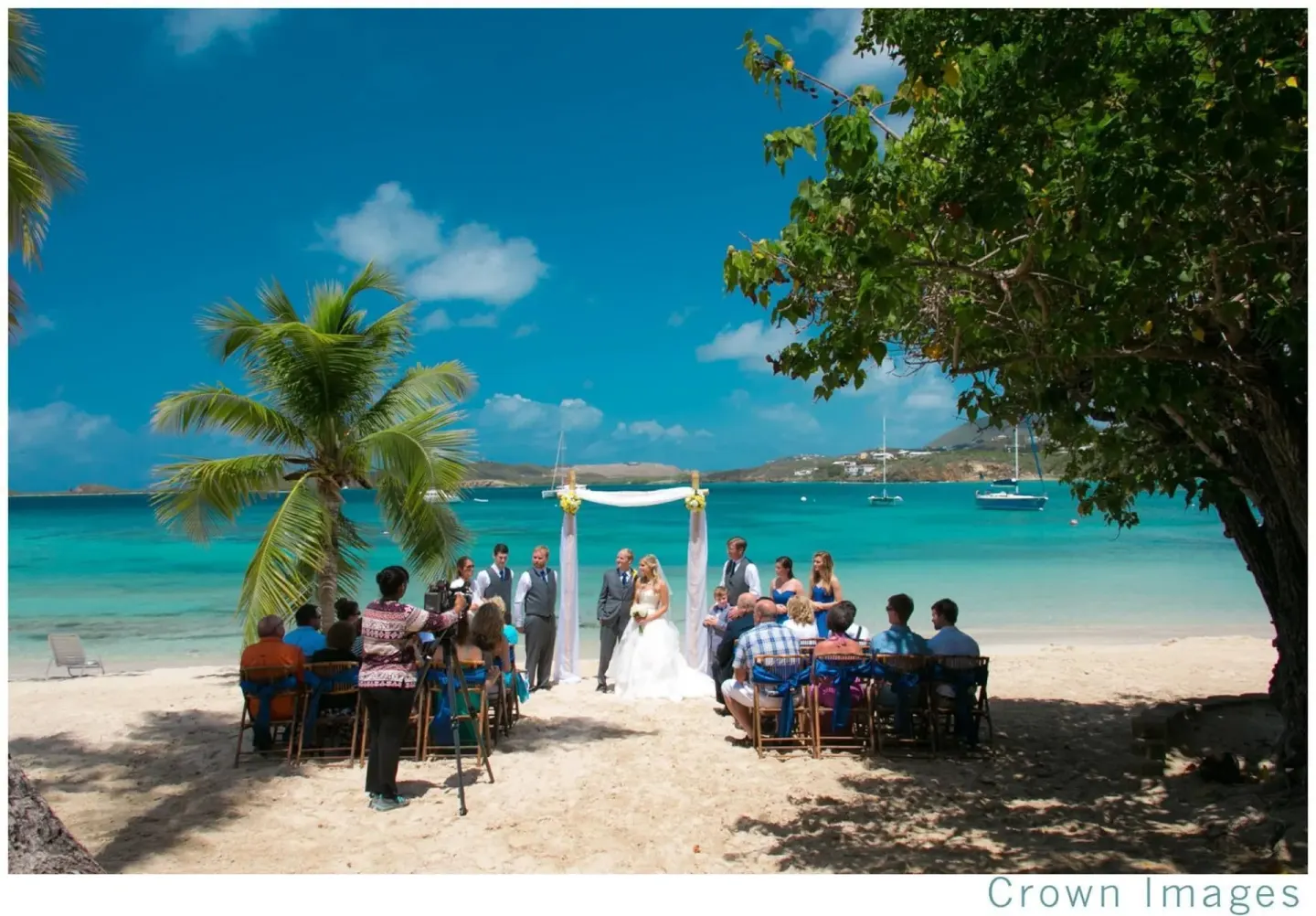 A beach wedding ceremony takes place by the water at Secret Harbour Beach Resort.