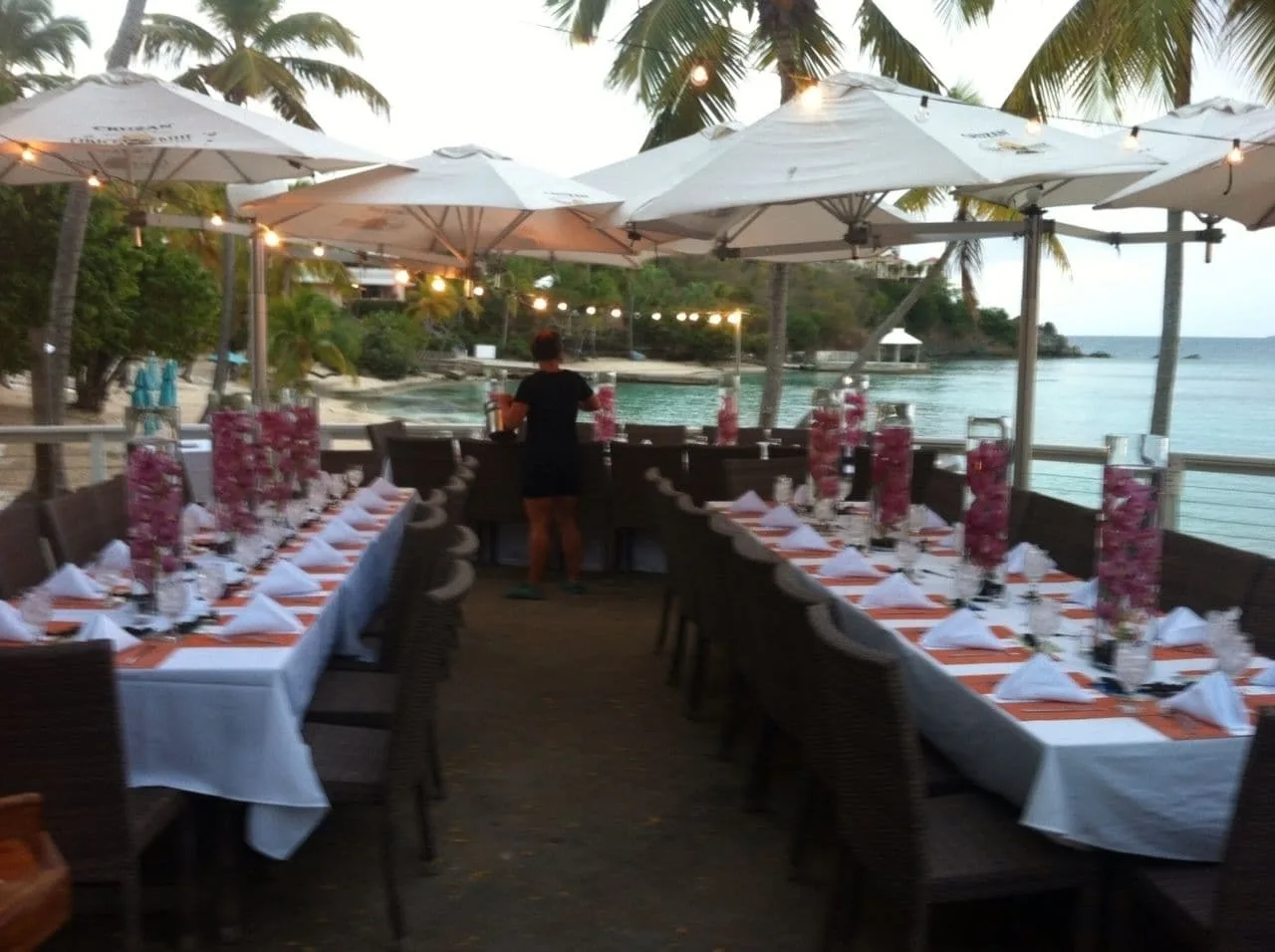 Long outdoor event tables are set by the water at Secret Harbour Beach Resort.