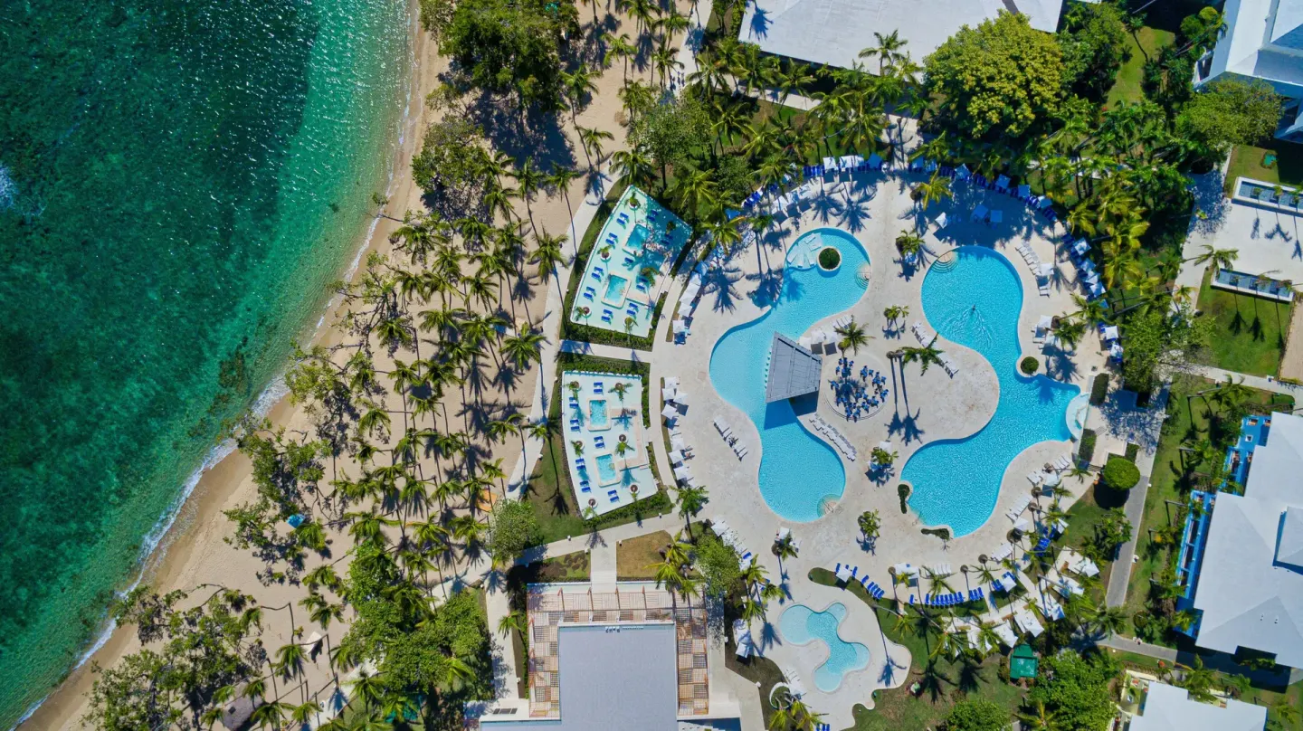Aerial view of the beachfront pools and palm-lined beach at Senator Puerto Plata.