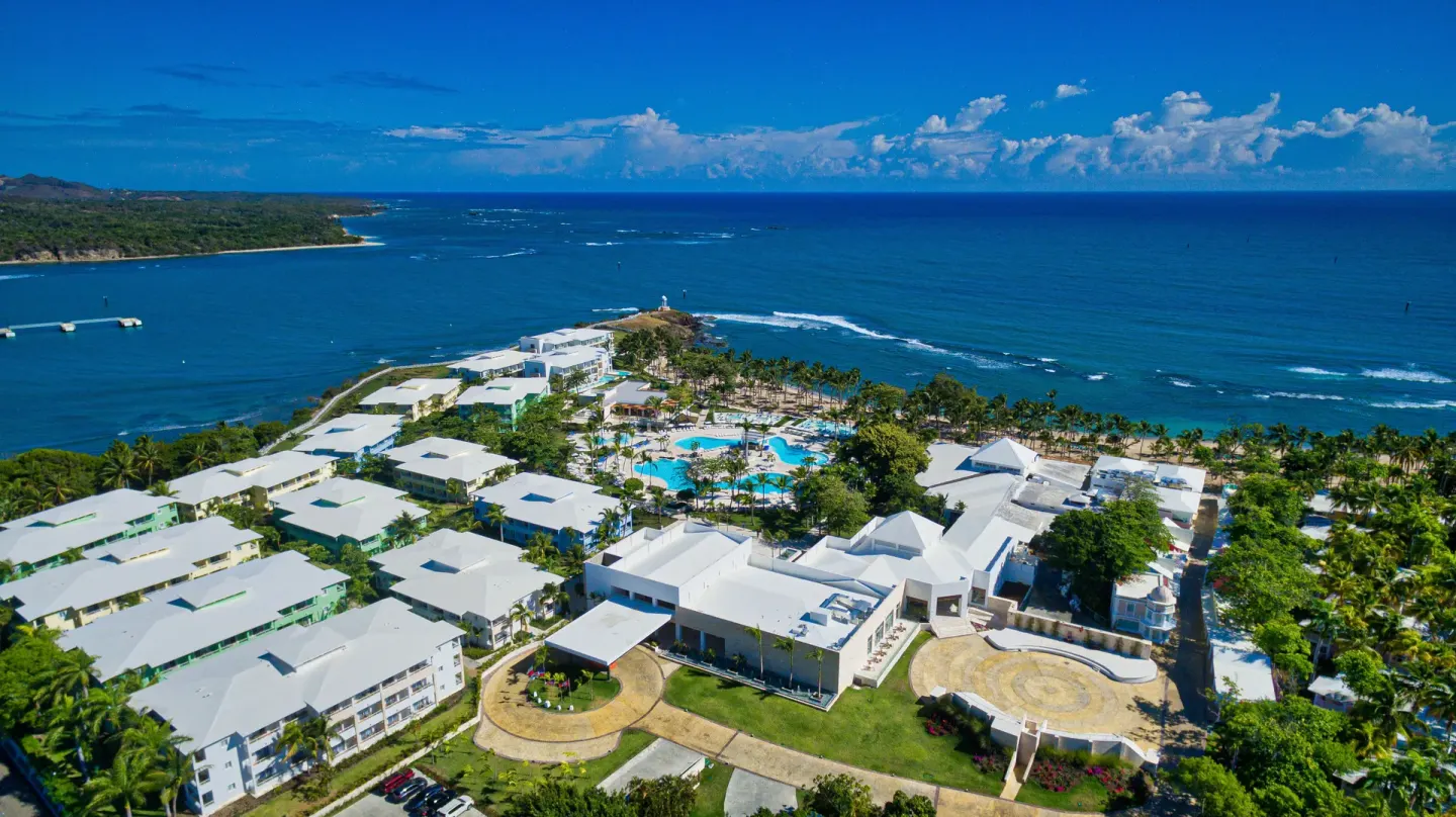 Aerial coastline view of Senator Puerto Plata with resort buildings, pools, and the ocean.