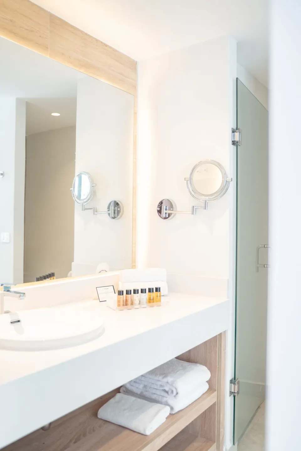 Bright bathroom vanity with mirror and glass shower at Senator Puerto Plata.