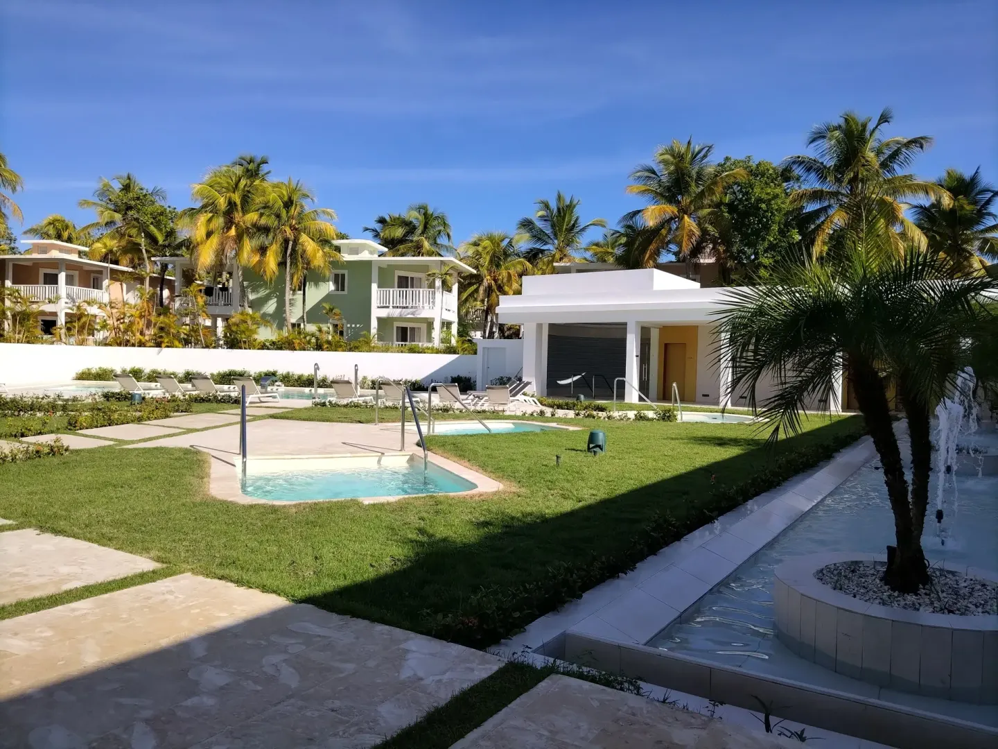 Garden plunge pools and palm-lined buildings at Senator Puerto Plata.