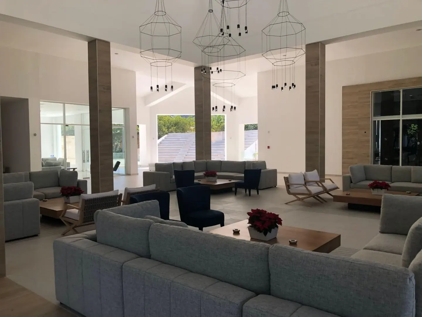 Lobby lounge at Senator Puerto Plata with pale sofas, low tables, and hanging wire lights.