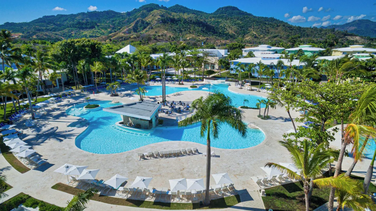 Aerial view of the main pool complex and mountain backdrop at Senator Puerto Plata.