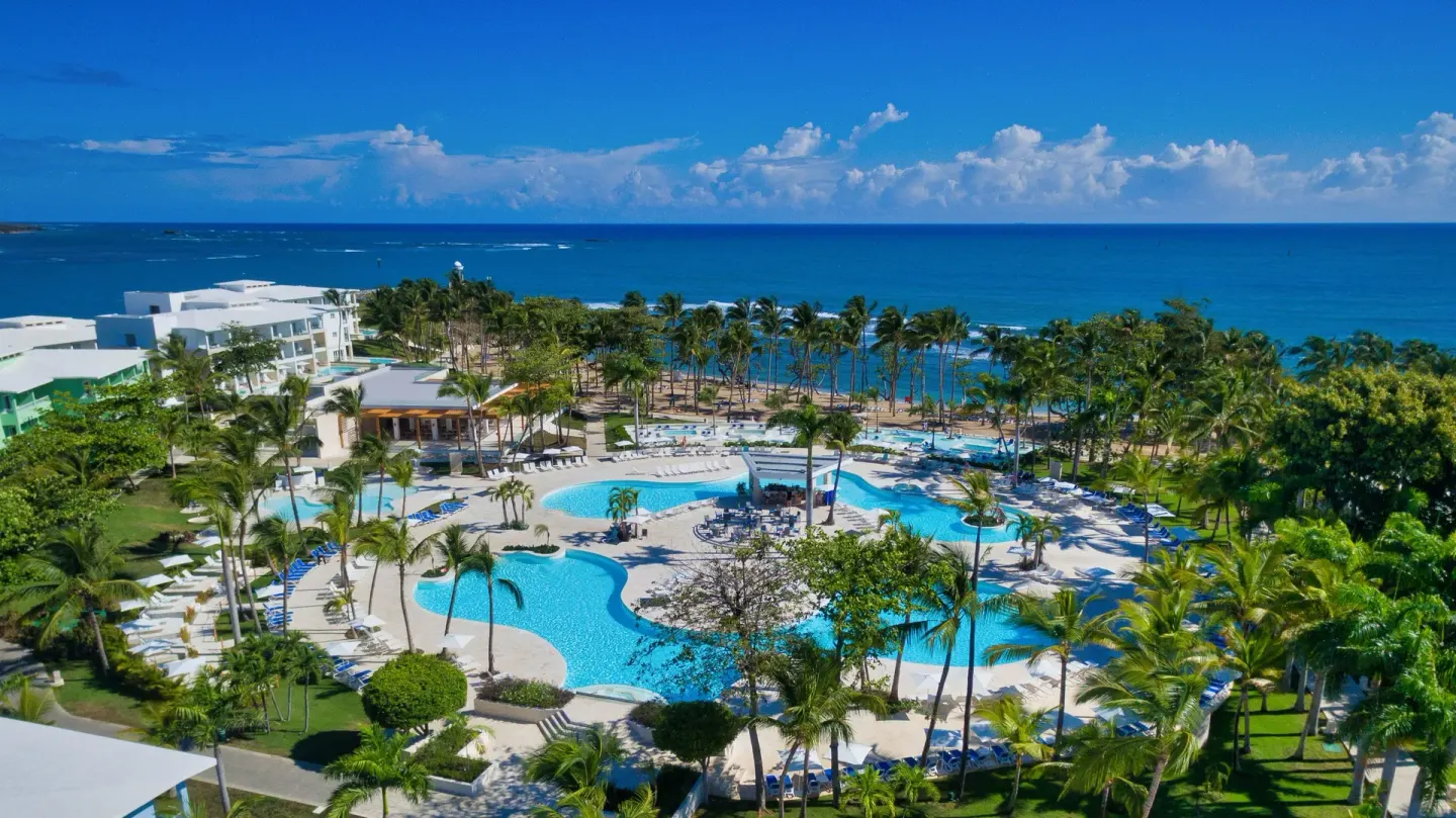 Aerial view of pools, palm gardens, and the beachfront at Senator Puerto Plata.