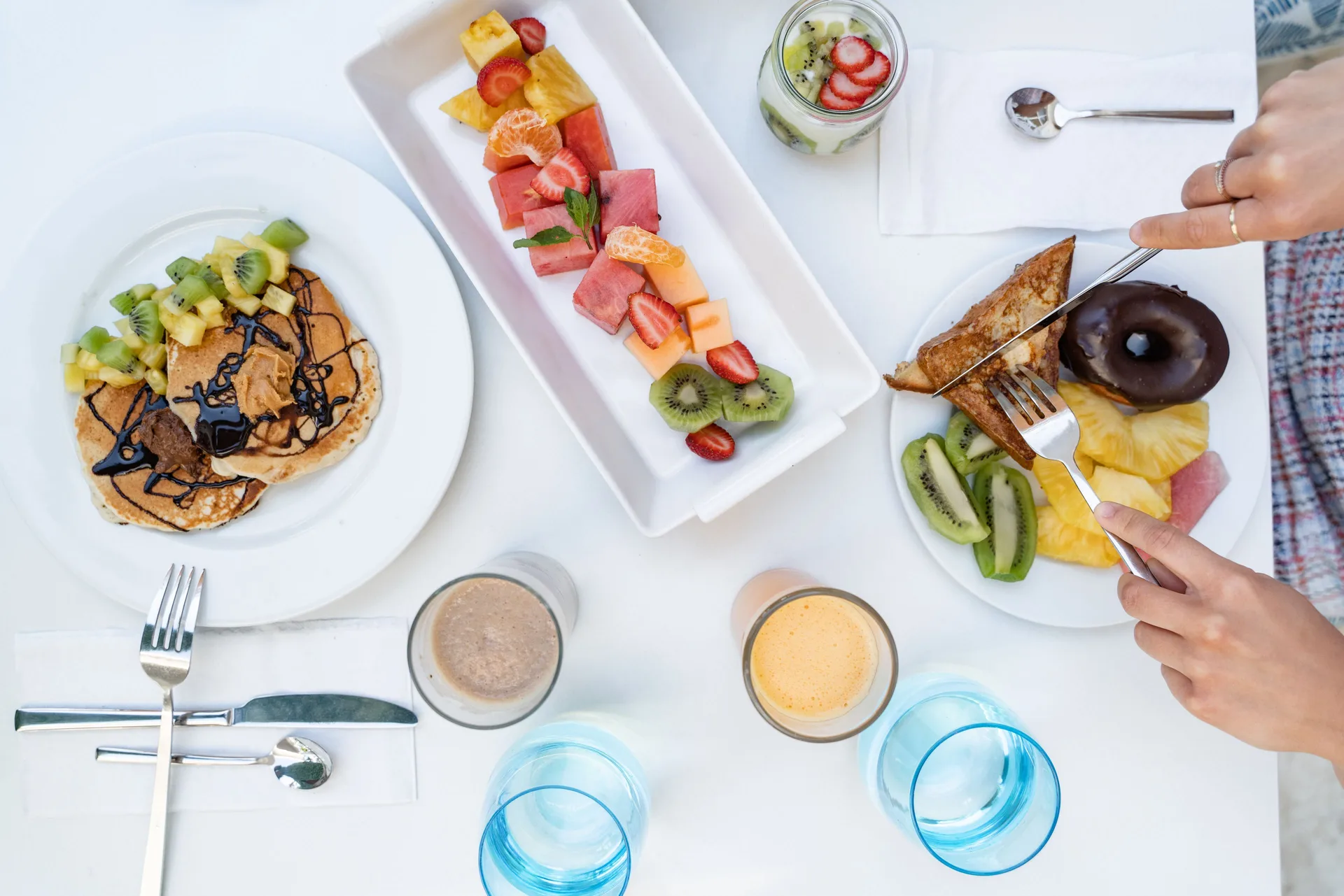 Breakfast plates with fruit, pancakes, toast, and drinks at Senator Puerto Plata.