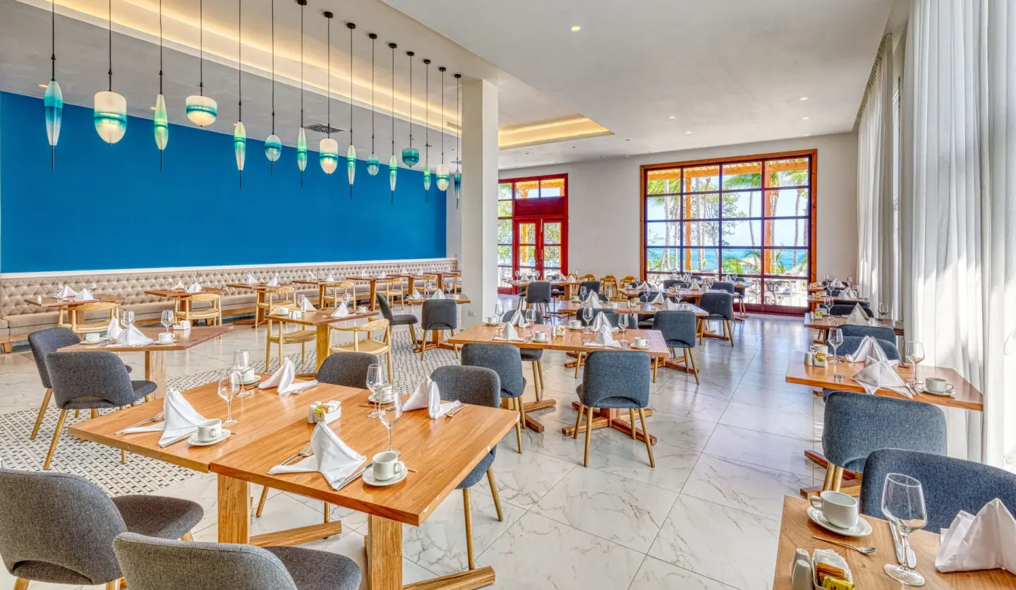 A restaurant dining room with a blue feature wall at Senator Puerto Plata.