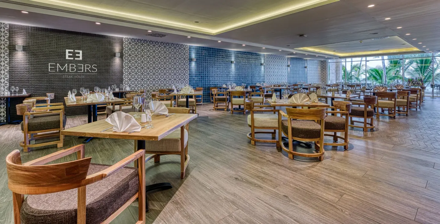 The Embers dining room with set tables and patterned walls at Senator Puerto Plata.