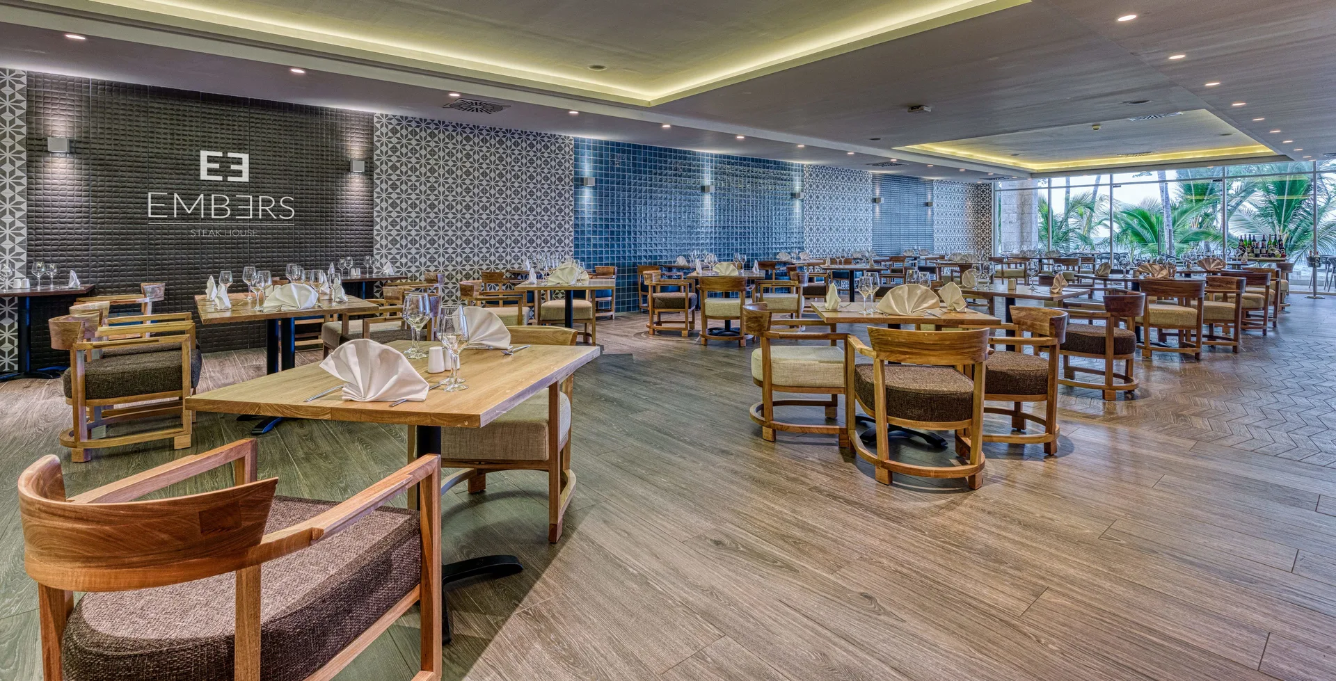 The Embers dining room with set tables and patterned walls at Senator Puerto Plata.