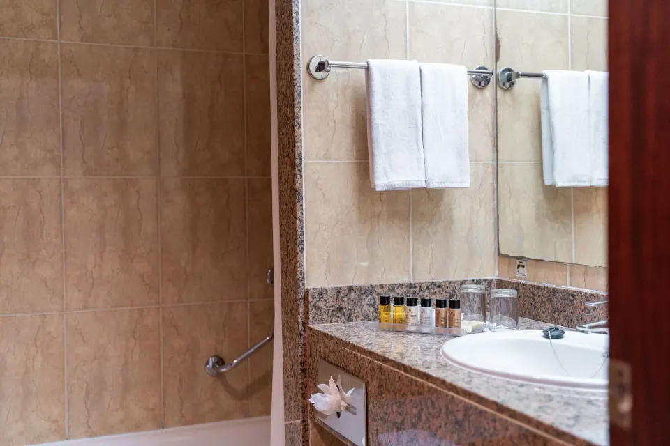 Senator Puerto Plata bathroom at Senator Puerto Plata with sink, mirror, towels, amenities, and tub.