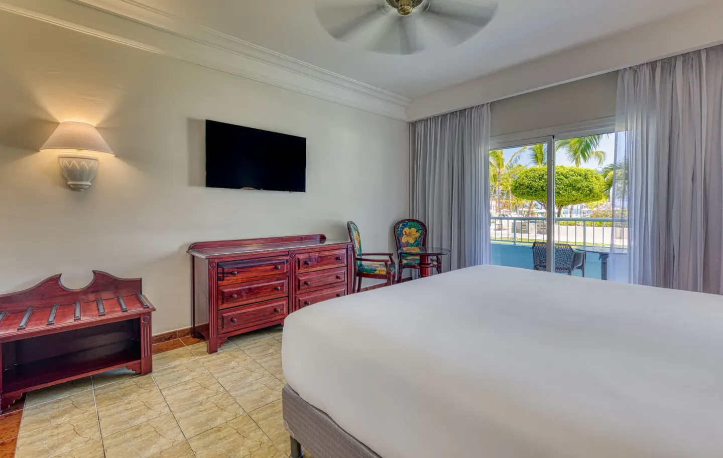Senator Puerto Plata junior suite with bed, dresser, TV, and balcony doors.